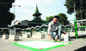 A worker paints the graveyard where Chief Minister Omar Abdullah will offer prayers on Martyrs Day on Saturday. 
