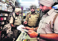 Policemen seize pirated CDs and DVDs at Bhadaur House in Ludhiana on Friday.