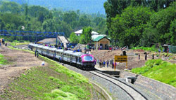 Passengers travel on the roof of the Banihal-Qazigund train in Anantnag district on Saturday. Tribune photo: Amin War