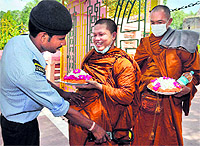 A security guard checks Buddhist monks as they enter the Mahabodhi temple in Bodh Gaya on Saturday
