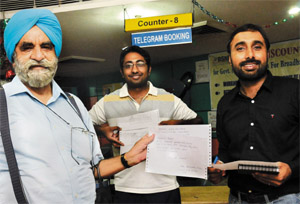 Col Jatinder Singh, Anshul Garg and Napinder Brar send their last telegram to their family members before the discontinuance of services by BSNL on Sunday at Sector 17, Chandigarh. 