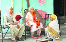 Women use hand fans during an unscheduled power cut in Jalandhar. 