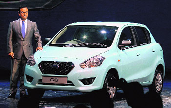 Nissan Motor Co. President and CEO Carlos Ghosn poses for the media with Datsun Go during its global launch in Gurgaon on Monday