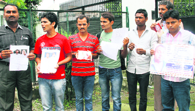 Relatives show the photographs of their missing kin at the Secretariat in Dehradun on Monday.