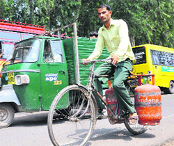 Employees of a gas agency carry LPG cylinders for home delivery in Jammu. 