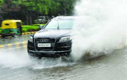 A car driver wades through a flooded road after a downpour in New Delhi on Tuesday. Tribune photo: Mukesh Aggarwal