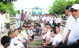 Members of the Dainik Yatri Sangh detain Chhindwara Express at Tohana in Fatehabad on Tuesday