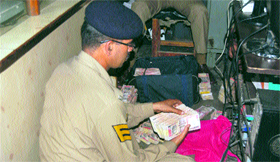 A policeman counts currency notes recovered from a car at Deothsidh on Tuesday.