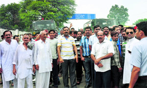 Residents block Jammu-Poonch highway in Akhnoor on Tuesday. 