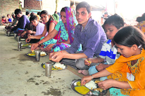 Amarnath yatris enjoy langar at the Hanuman temple in Srinagar on Tuesday. 