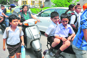 Due to strike by private bus operators, parents pick up children after school in Ludhiana. 