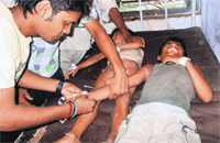 Schoolchildren being treated at a hospital after they complained of sickness following mid-day meal at a village in Chapra district of Bihar on Tuesday.  PTI