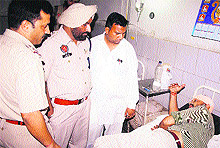 Policemen speak to the injured at a hospital in Amritsar on Wednesday