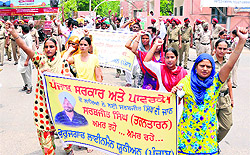 Members of the Unemployed Linesmen Union, Punjab, accompanied by their families shout slogans against the state government during a rally held in support of their demands in Bathinda on Wednesday