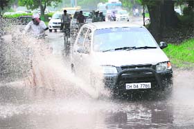 A car crosses a waterlogged road in Chandigarh on Wednesday