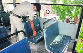 A policeman looks at the broken window glasses of a police vehicle after the protest by Haryana youths in Dera Bassi on Wednesday