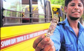 The conductor of a school bus shows an expired medicine kept in the first aid box, at Mohali on Wednesday