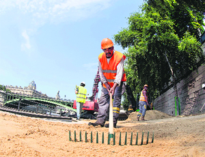 Workers create a temporary artificial beach along the Seine river for the 12th edition of Paris-Plage holiday programme in Paris on Wednesday.