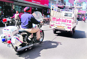 A PCR vehicle being towed away by a goods carrier on a road in Amritsar.