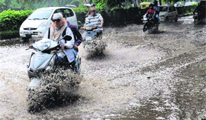 Motorists pass through a waterlogged road after rain in Chandigarh on Thursday.