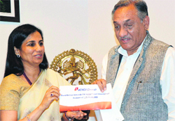 Chanda Kochhar, MD and CEO of ICICI Bank, presents a cheque for Rs 15 crore to Chief Minister Vijay Bahuguna towards the relief fund in Dehradun on Thursday.  PTI