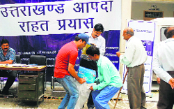Disaster-affected people get relief material at a camp organised by the Confederation of Indian industry at Narayabagar in Chamoli district on Thursday. A Tribune photo