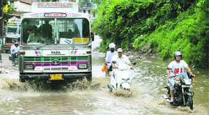 Vehicles wade through a waterlogged road in Mandi on Friday. 