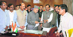 BJP president Satpal Satti presents a cheque for Rs 5.2 lakh to the CM in Shimla on Friday. 