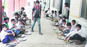 Students having mid-day meal, sans any rug, at Government Middle School on Garha Road in Jalandhar on Friday.