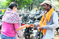An employee of the parking contractor issues a manual slip to a woman in Ludhiana on Friday. Photo: Inderjeet Verma