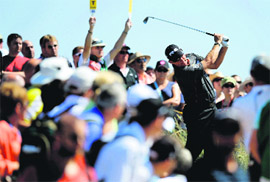 People watch as Westwood tees off. 