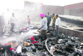 Firemen extinguish the fire that erupted at Quality Thread Mill on the Batala road in Amritsar on Saturday.