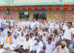 The kin of the deceased woman block traffic in protest against the doctor, whom they accused of negligence, outside his hospital in Bathinda on Saturday. 