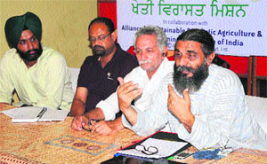 Umendra Dutt (right), director, Kheti Virasat Mission, an NGO, addresses media persons in Bathinda on Saturday. 