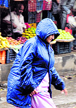 A lady caught in the rain that lashed the entire city of Jammu on Saturday