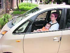 (Left) The woman is holding the child in her lap, which is unsafe in event of an accident, the child will get hurt. 