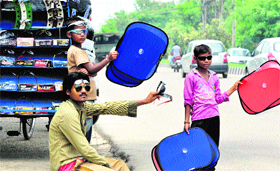 Roadside vendors sell sunglasses and sun-shades for cars in Jammu on Sunday.