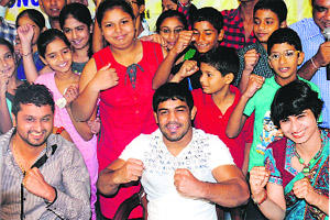 Wrestler Sushil Kumar strikes a pose with national kickboxing medallists. 