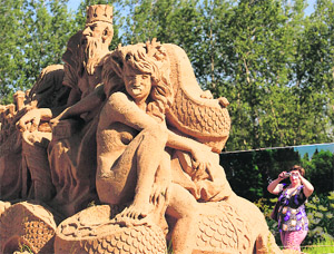 A visitor photographs a sand sculpture at the Russian folk fairy tales themed exhibition on Sunday.