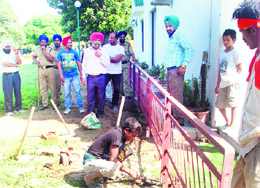 GMADA officials oversee the installation of a railing at a spot from where an encroachment was removed at Sector 70 in Mohali on Monday. 