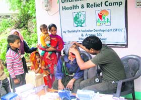 Dr SS Ansari checks a patient at a health camp organised by the SFID at Guptkashi on Monday