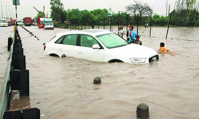 A car gets stuck on waterlogged Delhi-Jaipur National Highway at Hero Honda Chowk in Gurgaon on Saturday. 