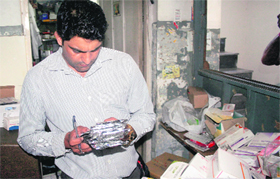 A member of the raiding party of the Vigilance Bureau of the Punjab Health Department checks the unaccounted drugs stocked at Rattan Hospital in Jalandhar on Monday.