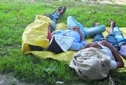 Men take nap at a park in Srinagar on Monday.