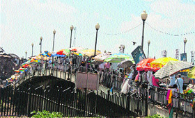 Vendors sell goods on a bridge after four days of strike and curfew in Srinagar on Monday.