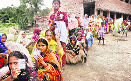 Women wait in a queue at a polling station in Murshidabad district of West Bengal on Monday.