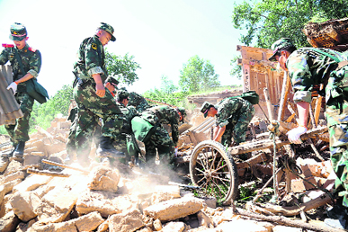 Rescuers search for survivors in the ruins of a house at Dingxi in Gansu Province on Monday.