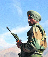 An Army jawan keeps a vigil in the Drass sector, with the Tiger Hill in the background. 