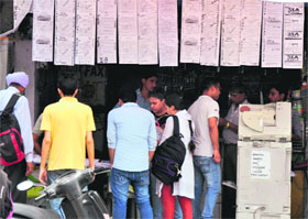  Unemployed youths sift through jobs advertised by different agencies at a shop in Jammu on Tuesday.