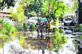 A man paddles his way through a waterlogged road in Jammu.